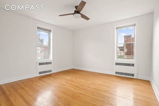76-12 35th Ave Unit 6J, New York City, NY 11372 - empty room featuring radiator heating unit, light wood finished floors, and a ceiling fan
