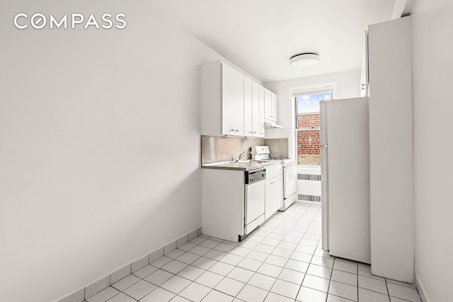 76-12 35th Ave Unit 6J, New York City, NY 11372 - kitchen with white appliances, radiator heating unit, white cabinetry, tasteful backsplash, and light countertops