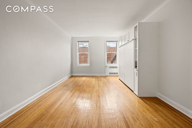 76-12 35th Ave Unit 6J, New York City, NY 11372 - unfurnished room with radiator and light wood finished floors