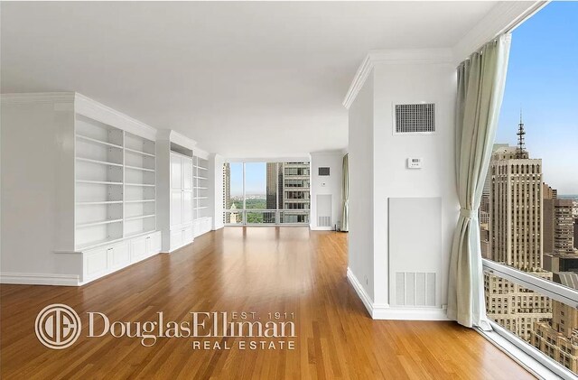 641 5th Ave Unit 35D, New York City, NY 10022 - unfurnished room with wood finished floors and built in features