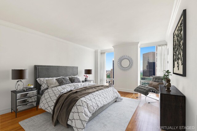 641 5th Ave Unit 35D, New York City, NY 10022 - bedroom featuring crown molding, wood finished floors, and a city view