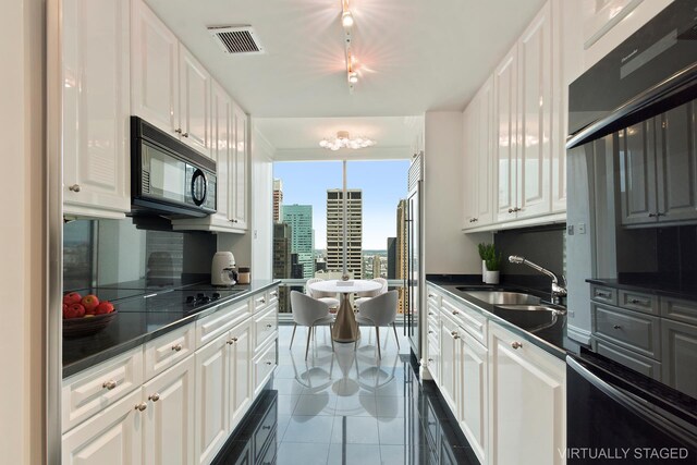 641 5th Ave Unit 35D, New York City, NY 10022 - kitchen with black microwave, dark countertops, white cabinetry, and floor to ceiling windows