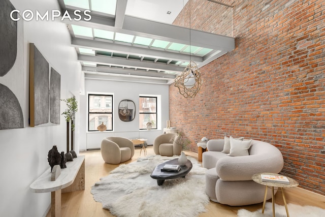74 Warren St Unit 5W, New York City, NY 10007 - living area with a high ceiling, wood finished floors, and brick wall