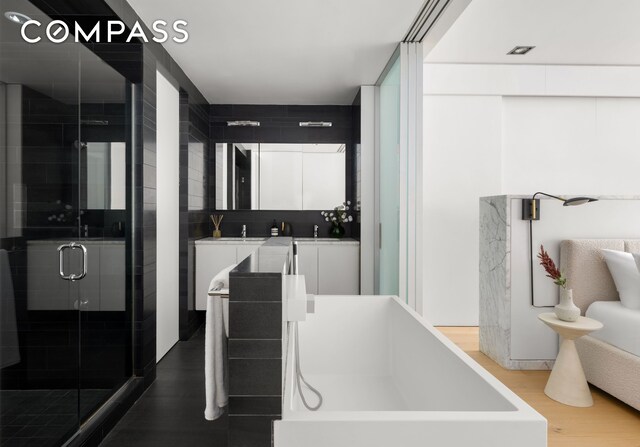 74 Warren St Unit 5W, New York City, NY 10007 - full bathroom featuring wood finished floors, a stall shower, and vanity