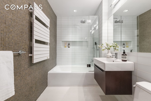 74 Warren St Unit 5W, New York City, NY 10007 - full bathroom with tile walls, vanity,  shower combination, tile patterned floors, and recessed lighting