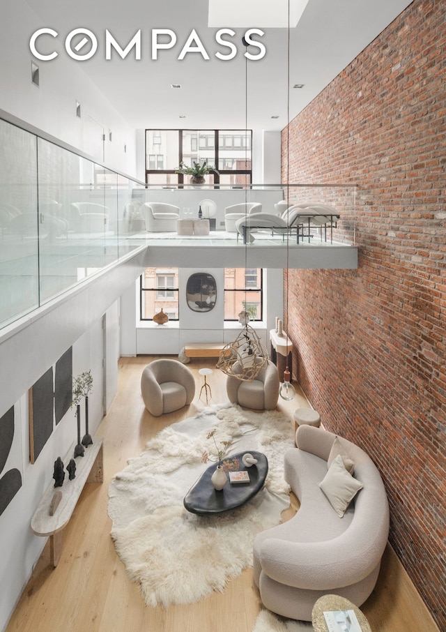 74 Warren St Unit 5W, New York City, NY 10007 - living room with wood finished floors, a towering ceiling, and brick wall