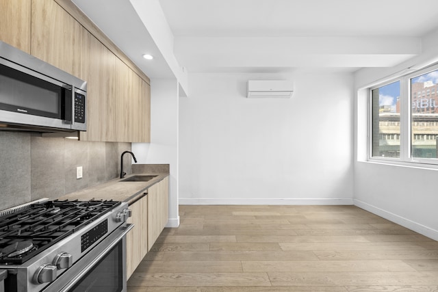 24-16 Queens Plz S Unit 3G, New York City, NY 11101 - kitchen featuring light brown cabinetry, appliances with stainless steel finishes, modern cabinets, a wall unit AC, and light wood-type flooring