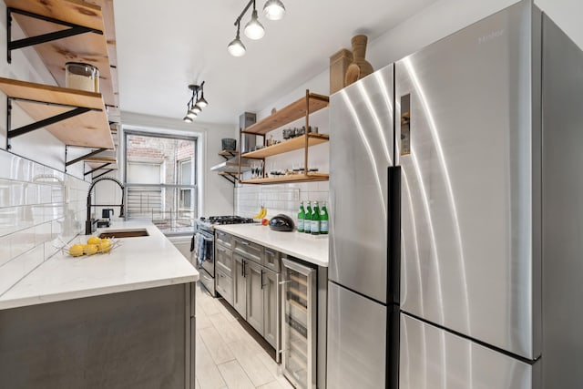 1075 Grand Concourse Unit 1G, New York City, NY 10452 - kitchen with stainless steel appliances, beverage cooler, backsplash, open shelves, and light stone countertops