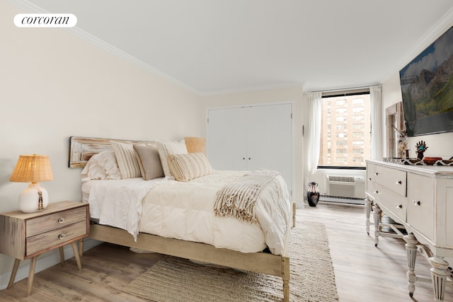 1641 3rd Ave Unit 8K, New York City, NY 10128 - bedroom with crown molding, light wood-style floors, and a wall mounted air conditioner