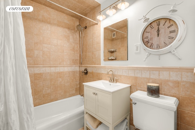 1641 3rd Ave Unit 8K, New York City, NY 10128 - bathroom featuring shower / bath combo, vanity, tile walls, and a wainscoted wall