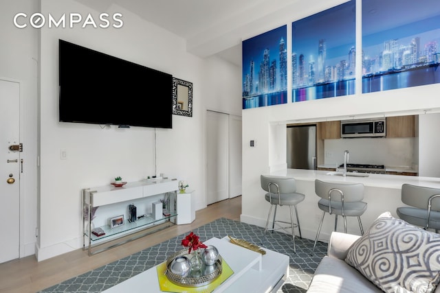 310 E 46th St Unit 20H, New York City, NY 10017 - living room featuring wood finished floors and a towering ceiling