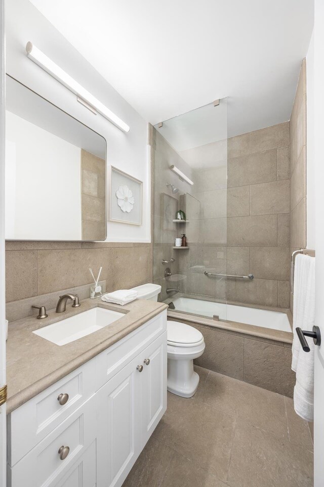 301 W 57th St Unit 16C, New York City, NY 10019 - bathroom with vanity, tiled shower / bath combo, tile walls, and tile patterned flooring