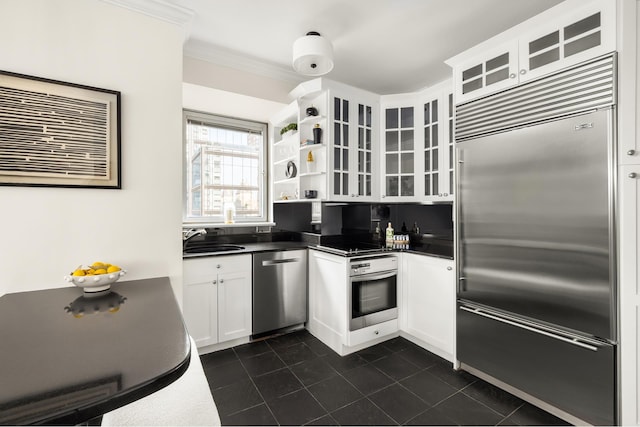 301 W 57th St Unit 16C, New York City, NY 10019 - kitchen with stainless steel appliances, dark countertops, dark tile patterned floors, white cabinetry, and glass insert cabinets