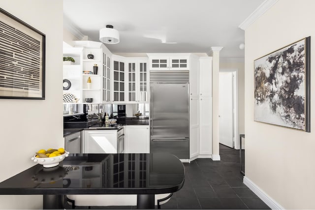 301 W 57th St Unit 16C, New York City, NY 10019 - kitchen featuring built in refrigerator, dark countertops, white cabinets, crown molding, and glass insert cabinets