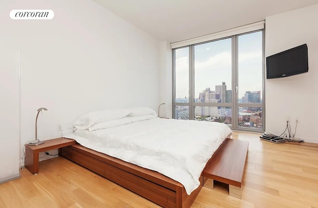 310 W 52nd St Unit 18H, New York City, NY 10019 - bedroom featuring floor to ceiling windows and light wood-style floors