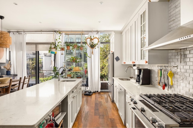 127 Cooper St, New York City, NY 11207 - kitchen with stainless steel appliances, wall chimney exhaust hood, wood-type flooring, white cabinets, and glass insert cabinets
