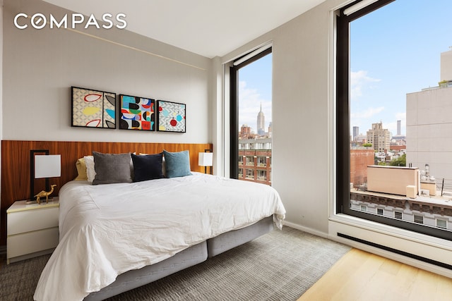 505 W 19th St Unit 7B, New York City, NY 10011 - bedroom featuring a view of skyline, multiple windows, and wood finished floors