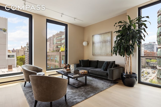 505 W 19th St Unit 7B, New York City, NY 10011 - living area with rail lighting, wood finished floors, and plenty of natural light
