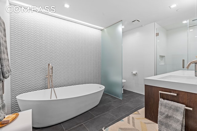 335 W 38th St Unit 6, New York City, NY 10018 - full bathroom featuring vanity, a freestanding bath, tile walls, and tile patterned flooring