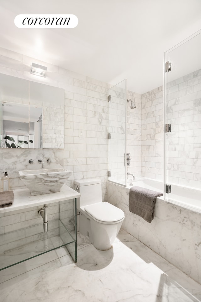 205 E 22nd St Unit 1Ab, New York City, NY 10010 - bathroom with tile walls, tiled shower / bath, and marble tiled floors