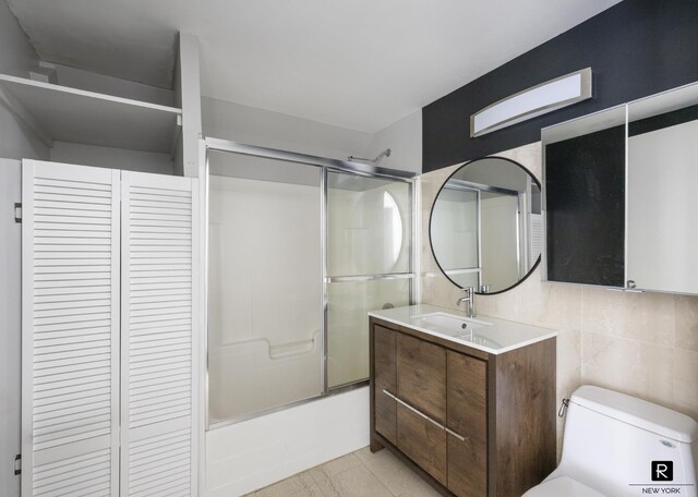 50 Bridge St Unit 506, New York City, NY 11201 - full bathroom with a closet, vanity, bath / shower combo with glass door, tile walls, and tasteful backsplash