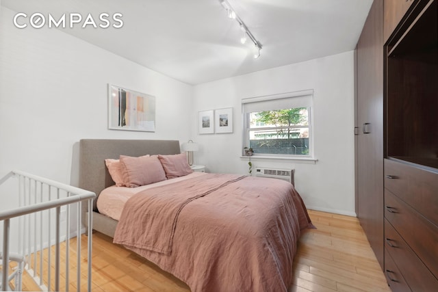 211 Thompson St Unit Gld, New York City, NY 10012 - bedroom featuring light wood-style flooring, rail lighting, and a wall unit AC