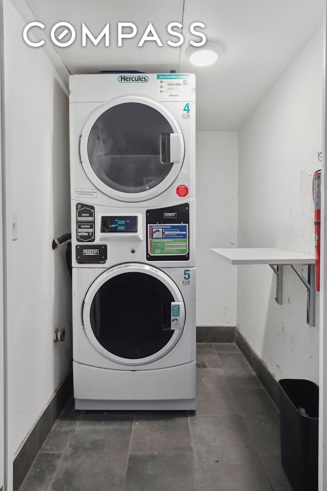 211 Thompson St Unit Gld, New York City, NY 10012 - laundry area with stacked washing machine and dryer and baseboards