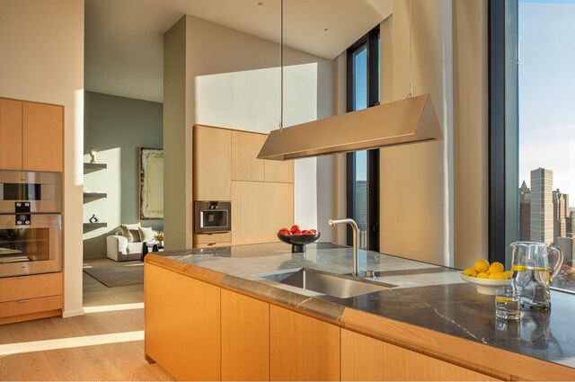 30 Front St Pha, Pha, New York City, NY 11201 - kitchen featuring wall chimney exhaust hood, high vaulted ceiling, light wood finished floors, modern cabinets, and light brown cabinets