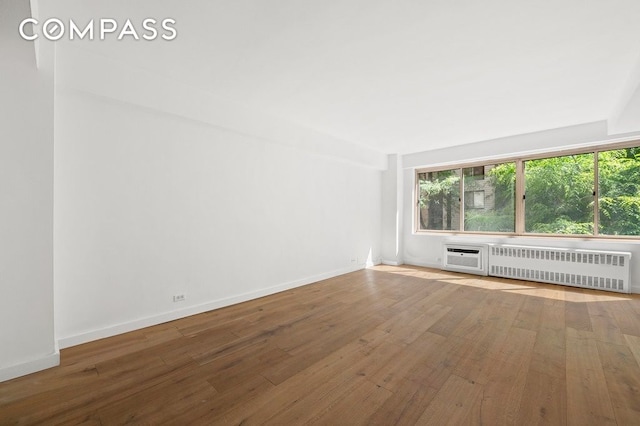 225 E 46th St Unit 2G, New York City, NY 10017 - spare room with radiator, healthy amount of natural light, and wood finished floors