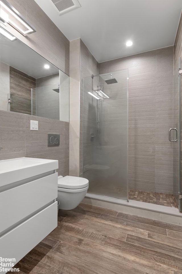 258 Winthrop St Unit 4A, New York City, NY 11225 - full bathroom featuring vanity, a stall shower, wood finished floors, tile walls, and recessed lighting