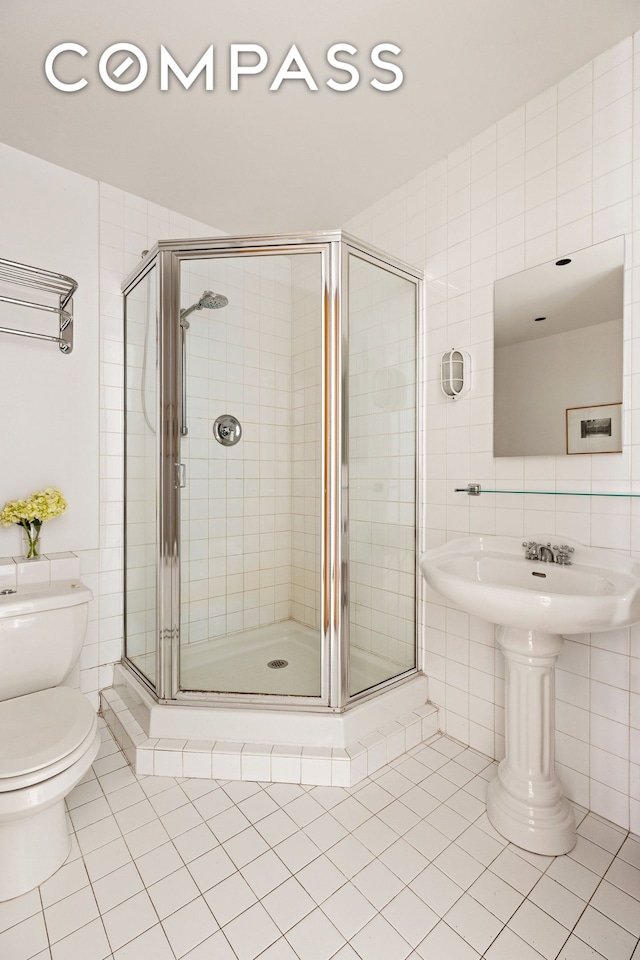 32 W 20th St Unit 9B, New York City, NY 10011 - bathroom featuring tile patterned flooring, tile walls, and a stall shower