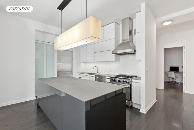 252 7th Ave Unit 10O, New York City, NY 10001 - kitchen featuring stainless steel appliances, wall chimney exhaust hood, modern cabinets, white cabinets, and dark wood finished floors