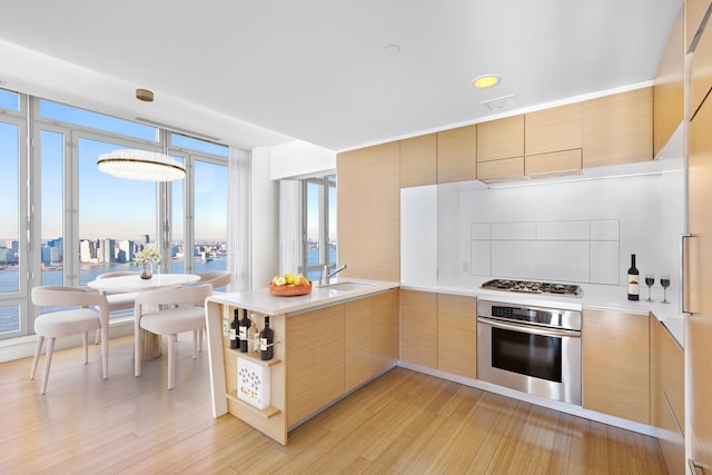 2 River Ter Unit Rh-8, New York City, NY 10282 - kitchen featuring stainless steel appliances, light wood-style floors, light brown cabinetry, and light countertops