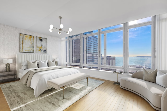 2 River Ter Unit Rh-8, New York City, NY 10282 - bedroom featuring wallpapered walls, a chandelier, a water view, and wood finished floors
