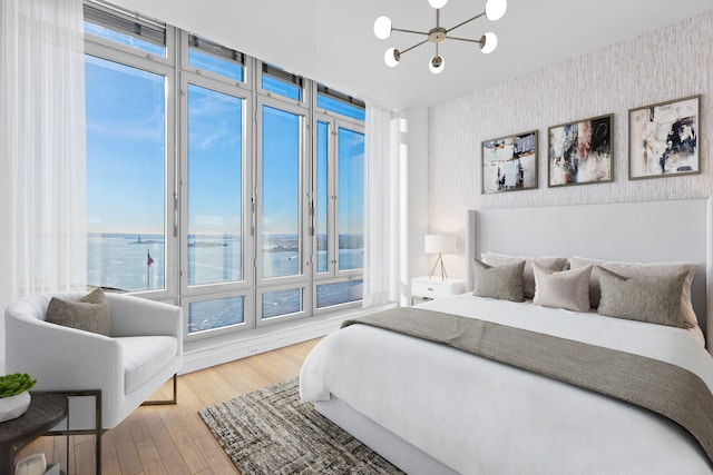 2 River Ter Unit Rh-8, New York City, NY 10282 - bedroom with wallpapered walls, a chandelier, a water view, and hardwood / wood-style flooring