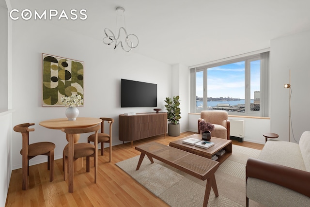 635 W 42nd St Unit 12D, New York City, NY 10036 - living room with light wood-type flooring and a chandelier