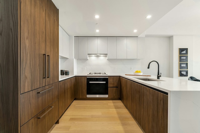 11 Hancock Pl Unit 501, New York City, NY 10027 - kitchen featuring black oven, modern cabinets, gas stovetop, white cabinets, and a peninsula
