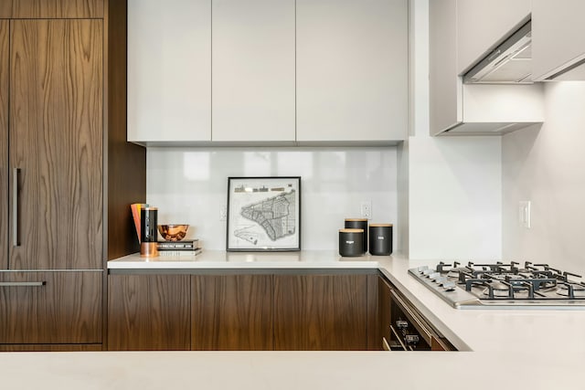 11 Hancock Pl Unit 501, New York City, NY 10027 - kitchen with modern cabinets, stainless steel gas stovetop, range hood, light countertops, and white cabinetry