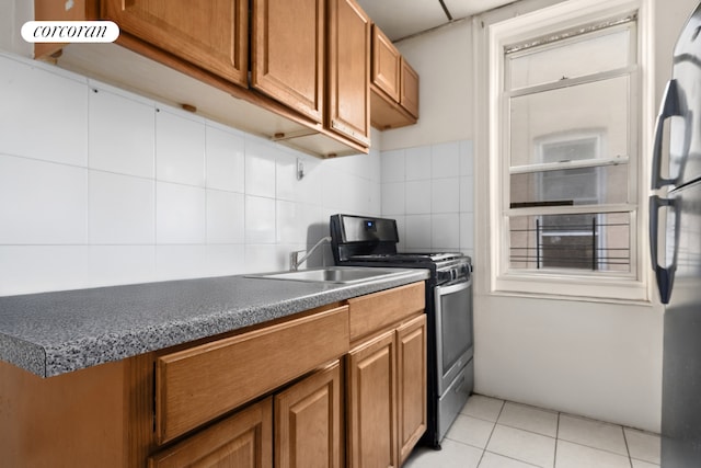 845 Bay Ridge Ave, New York City, NY 11220 - kitchen with appliances with stainless steel finishes, brown cabinets, backsplash, dark countertops, and light tile patterned floors