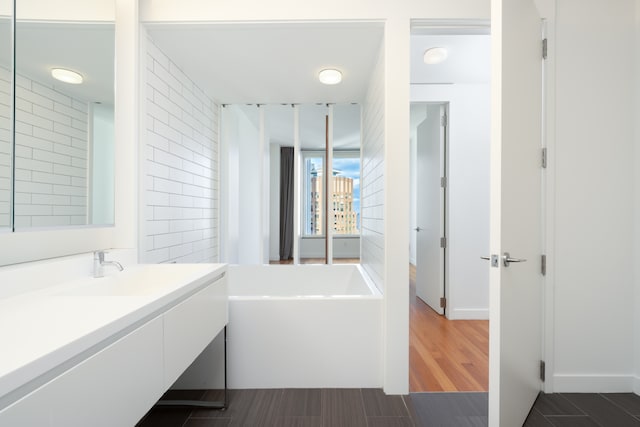 15 William St Unit 39F, New York City, NY 10004 - bathroom with vanity, a bath, and wood finished floors