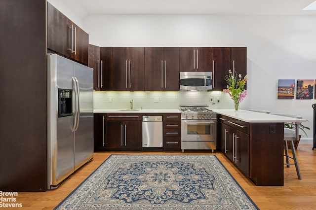 302 W 122nd St Unit 1, New York City, NY 10027 - kitchen featuring stainless steel appliances, a peninsula, light countertops, and decorative backsplash