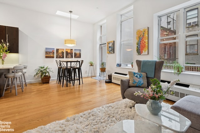 302 W 122nd St Unit 1, New York City, NY 10027 - living room featuring light wood finished floors, healthy amount of natural light, a towering ceiling, and radiator heating unit