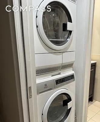 204 W 10th St Unit 18, New York City, NY 10014 - washroom with stacked washer / dryer and light tile patterned flooring