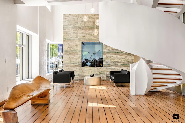 2 River Ter Unit 9-A, New York City, NY 10282 - living area with wood-type flooring, a towering ceiling, and stairs