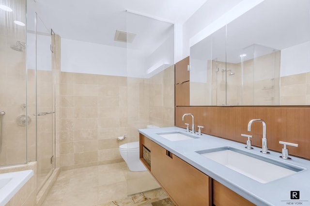 2 River Ter Unit 9-A, New York City, NY 10282 - bathroom featuring a stall shower, double vanity, a relaxing tiled tub, tile patterned flooring, and tile walls