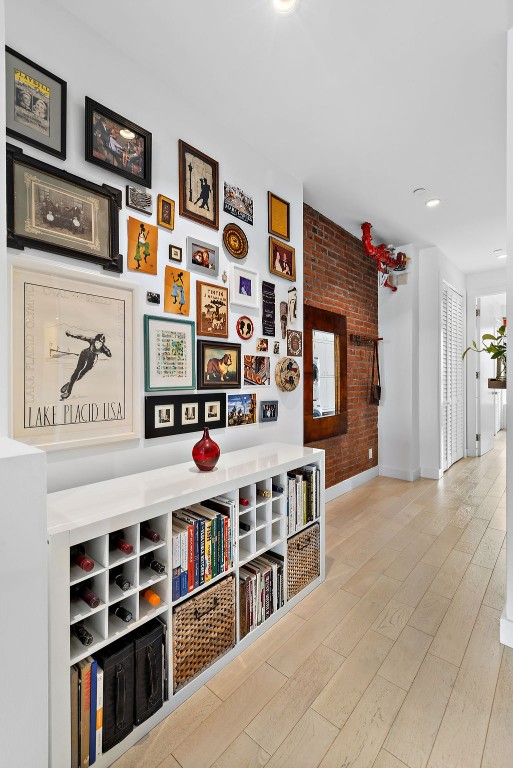 148 W 121st St Unit 5, New York City, NY 10027 - hall featuring brick wall, wood finished floors, and recessed lighting