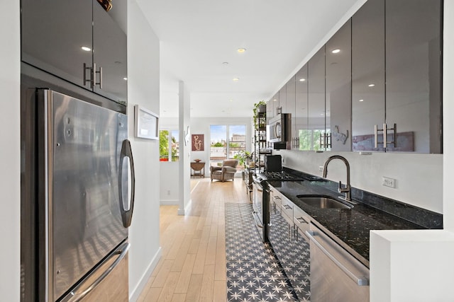 148 W 121st St Unit 5, New York City, NY 10027 - kitchen featuring stainless steel appliances, modern cabinets, dark stone counters, light wood finished floors, and gray cabinetry