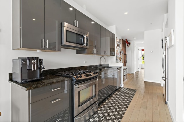 148 W 121st St Unit 5, New York City, NY 10027 - kitchen featuring stainless steel appliances, light wood-style floors, gray cabinetry, dark stone countertops, and recessed lighting