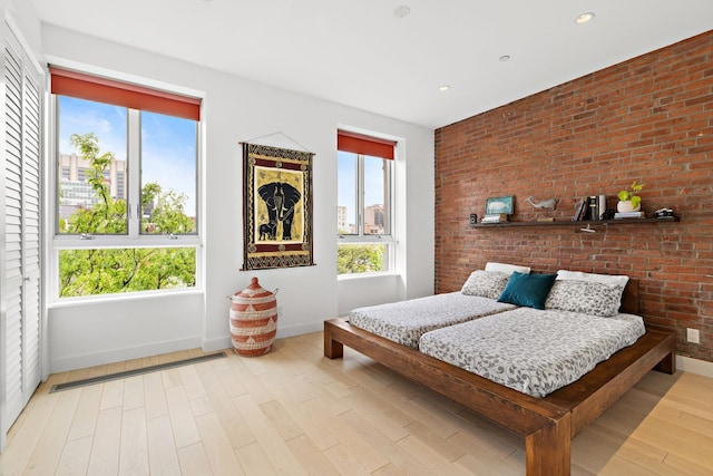 148 W 121st St Unit 5, New York City, NY 10027 - bedroom with wood finished floors, recessed lighting, and brick wall