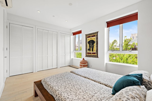 148 W 121st St Unit 5, New York City, NY 10027 - bedroom with multiple closets, multiple windows, recessed lighting, light wood finished floors, and a wall mounted air conditioner